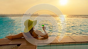 Summer time and Vacations. Women lifestyle relaxing and drinking juice orange so happy in luxury swimming pool sunbath,