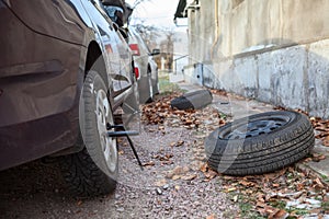 Summer tire wheels changing to snow studded tyres in autumn season. Backyard of house