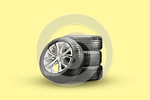 Summer tires and wheels-stack on a yellow background, new wheels