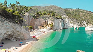 Summer touristic destination in Puglia, Italy: Faraglioni di Puglia Baia delle Zagare - Beach and faraglioni rocks formation