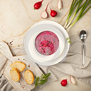 Summer traditional Ukrainian pink cold soup with beetroot, radish, yogurt, herbs. Okroshka. Light marble background