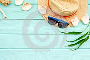 Summer travaling to the sea with straw hat, sun glasses, shells on mint green wooden background top view mock up