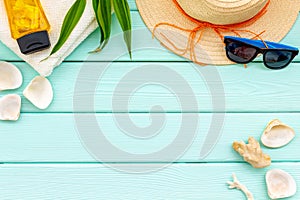 Summer travaling to the sea with straw hat, sun glasses, sunblock lotion on mint green background top view mock up