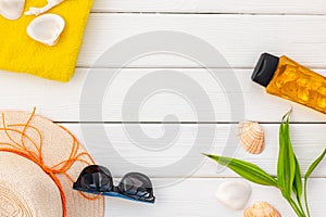 Summer travaling to the sea with straw hat, sun glasses, sunblock lotion on white wooden background top view mock up