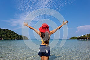 Summer travel Back view of young woman on the beach at Sea