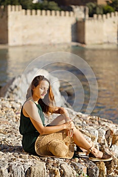 Summer travel concept. Female sitting on the rocks