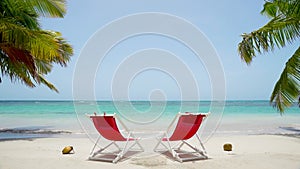 Summer travel concept on Mexico beach. Beach accessories on white sand beach behind two palm trees with sea views.