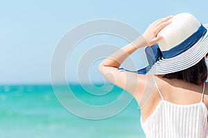 Summer Travel. Happy and Relax woman hand holding big hat on white sand beach,