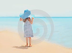 Summer travel photo pretty little girl in dress and straw hat