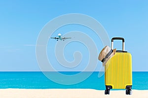 Summer travel and plan with yellow suitcase luggage in the sand beach. Travel in the holiday trips, airplane and blue sky backgrou