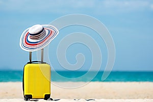 Summer travel and plan with yellow suitcase luggage in the sand beach. Travel in the holiday trips, airplane and blue sky backgrou