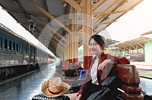 Summer, Travel, Vacation, Relax,  A smiling female tourist looks at the train station for a summer vacation, travel concept