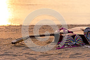 Summer traveling with guitar and Fashion woman swimsuit Bikini, fish star, sun glasses, hat on the sand beach in the holiday,