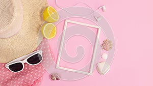 Summer trendy beach accessories move around copy space frame on pastel pink background. Stop motion flat lay