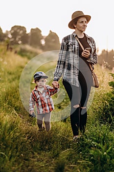 Summer trip with children to the mountains. Evening walk of a mother with a child in an alpine village in summer.