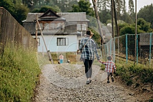 Summer trip with children to the mountains. Evening walk of a mother with a child in an alpine village in summer.