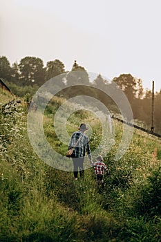 Summer trip with children to the mountains. Evening walk of a mother with a child in an alpine village in summer.