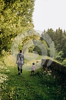 Summer trip with children to the mountains. Evening walk of a mother with a child in an alpine village in summer.