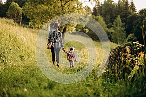 Summer trip with children to the mountains. Evening walk of a mother with a child in an alpine village in summer.