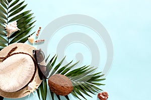 Summer, tropical turquoise background with a straw hat, coconut, sunglasses