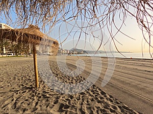 Summer umbrellas on the beach at la Malagueta urban sand beach at sunrise, Costa del Sol, Malaga, Spain, Europe