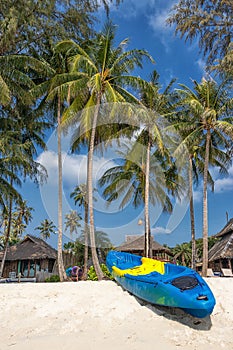 Summer vacation with activity on tropical beach concept. colorful kayak boat on white sand beach with coconut palm tree