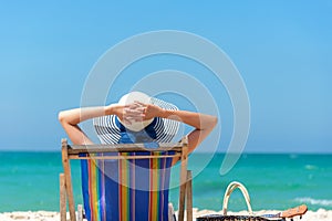 Summer Vacation. Beautiful young asian woman relaxing and happy on beach chair with cocktail coconut juice in holiday summer, blue