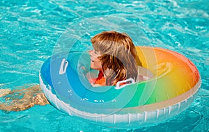 Summer vacation. Boy in swiming pool. Child at aquapark. Funny boy on inflatable rubber circle.