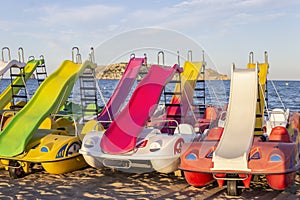 Summer vacation concept background.Pedal boats or paddle boats on beach sand .Mediterranean Sea, Spain