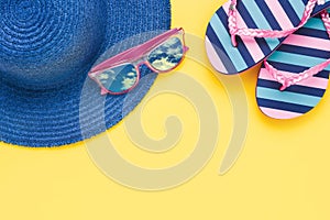 Summer vacation concept. Beach accessories on a yellow background. Top view, copy space