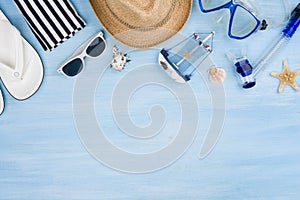 Summer vacation concept with beach items on blue wooden background