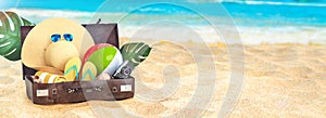 Summer vacation concept. Beach and the sea, sunny day summer banner. Flip flops, sun glasses, shells, camera, beach ball, luggage.