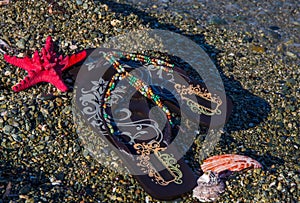 Summer vacation concept-flipflops with sea star and shells on the beach