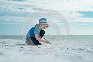 Summer vacation concept. Happy little kid walking on sea sandy beach. Travel and adventure kids concept. Lovely kid play