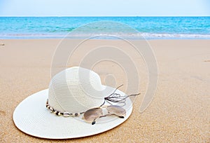 Summer vacation concept. Straw hat with sunglasses on tropical beach.