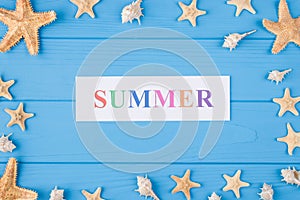 Summer vacation concept. Top above overhead view photo of word summer and seashells and seafish isolated on blue wooden background