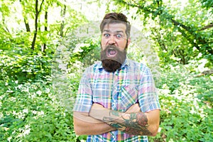 Summer vacation concept. United with environment. Man bearded hipster green trees background. Emotional nature lover