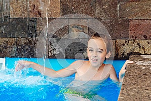 Summer vacation concept. Water games and water fun for kids. Cute boy having fun in the pool