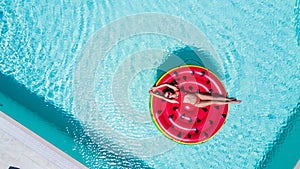 Summer Vacation. Enjoying woman in bikini on the inflatable mattress in the swimming pool