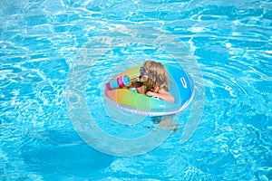 Summer vacation fun. Child swimming and jumping on the waves. Kids having fun at aquapark. Funny kid on inflatable