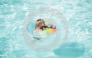 Summer vacation fun. Child swimming and jumping on the waves. Kids having fun at aquapark. Funny kid on inflatable