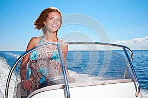 Summer vacation - girl driving a motor boat