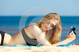 Summer vacation Girl with phone tanning on beach