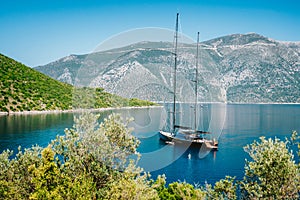 Summer vacation in Greece. Luxury black private yacht at anchor in beautiful sea lagoon. Ithaka island