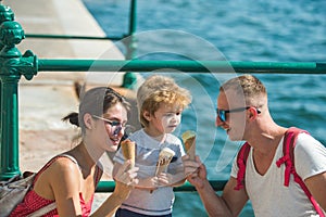 Summer vacation of happy family. Mother and father with son eat ice cream at sea. Child with father and mother. Family