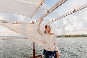 Summer vacation,happy women relaxing on the roof of yacht at sunset.Andaman sea Thailand