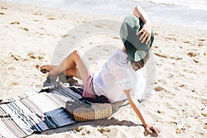 Summer vacation. Happy young boho woman relaxing and enjoying sunny warm day at ocean. Space for text. Stylish hipster girl in hat