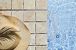 Summer vacation. Hat on the travertine stone by the beautiful swimming pool. Blue sea surface with waves, texture water.