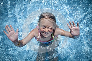 Summer vacation, healthy lifestyle and happy childhood concept. Top view of cute child girl having fun in swimming pool. Kid