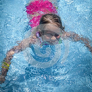 Summer vacation, healthy lifestyle and happy childhood concept.Young child girl splashing in swimming pool and having fun leisure